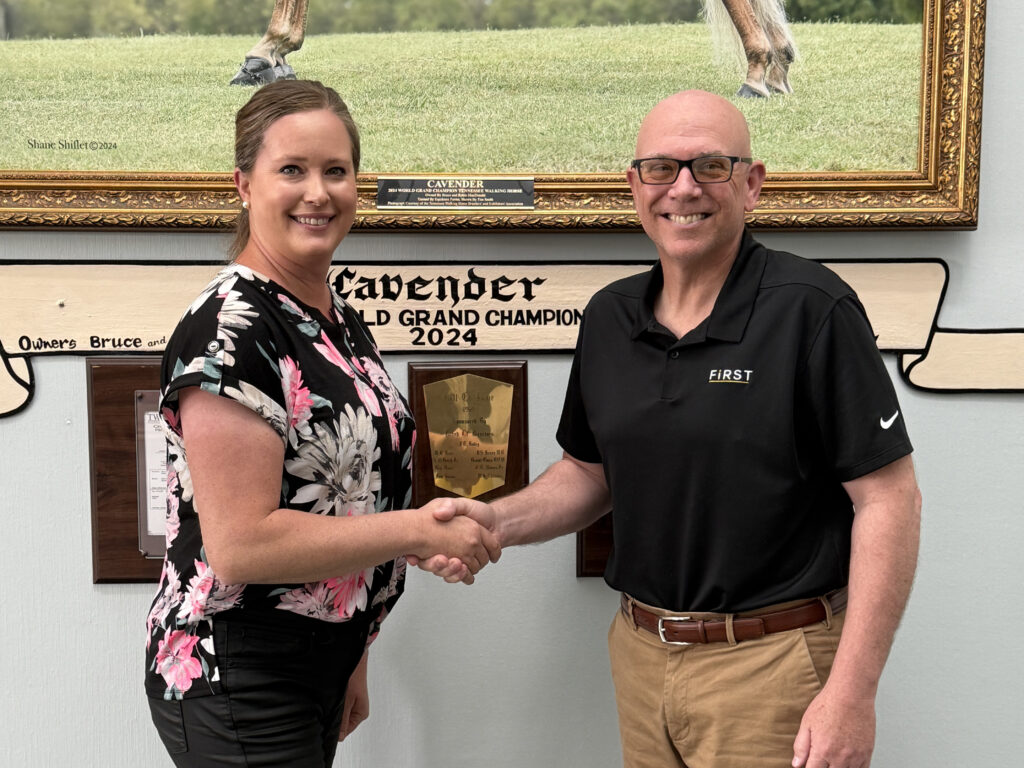 TWHBEA President Amanda Wright (left) shakes hands with First National Bank Vice President Kasey Kesselring (right)